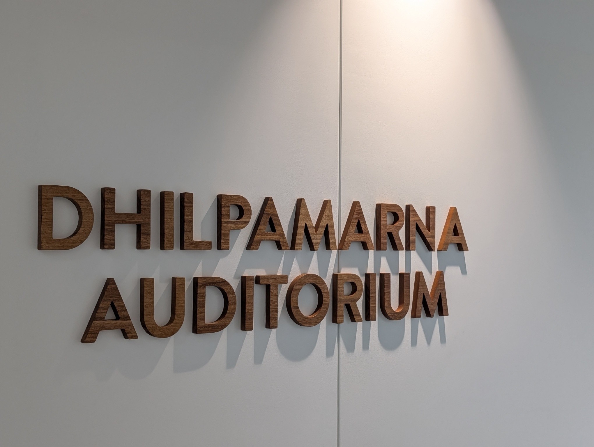The timber Dhilpamarna Auditorium signage mounted on the foyer wall