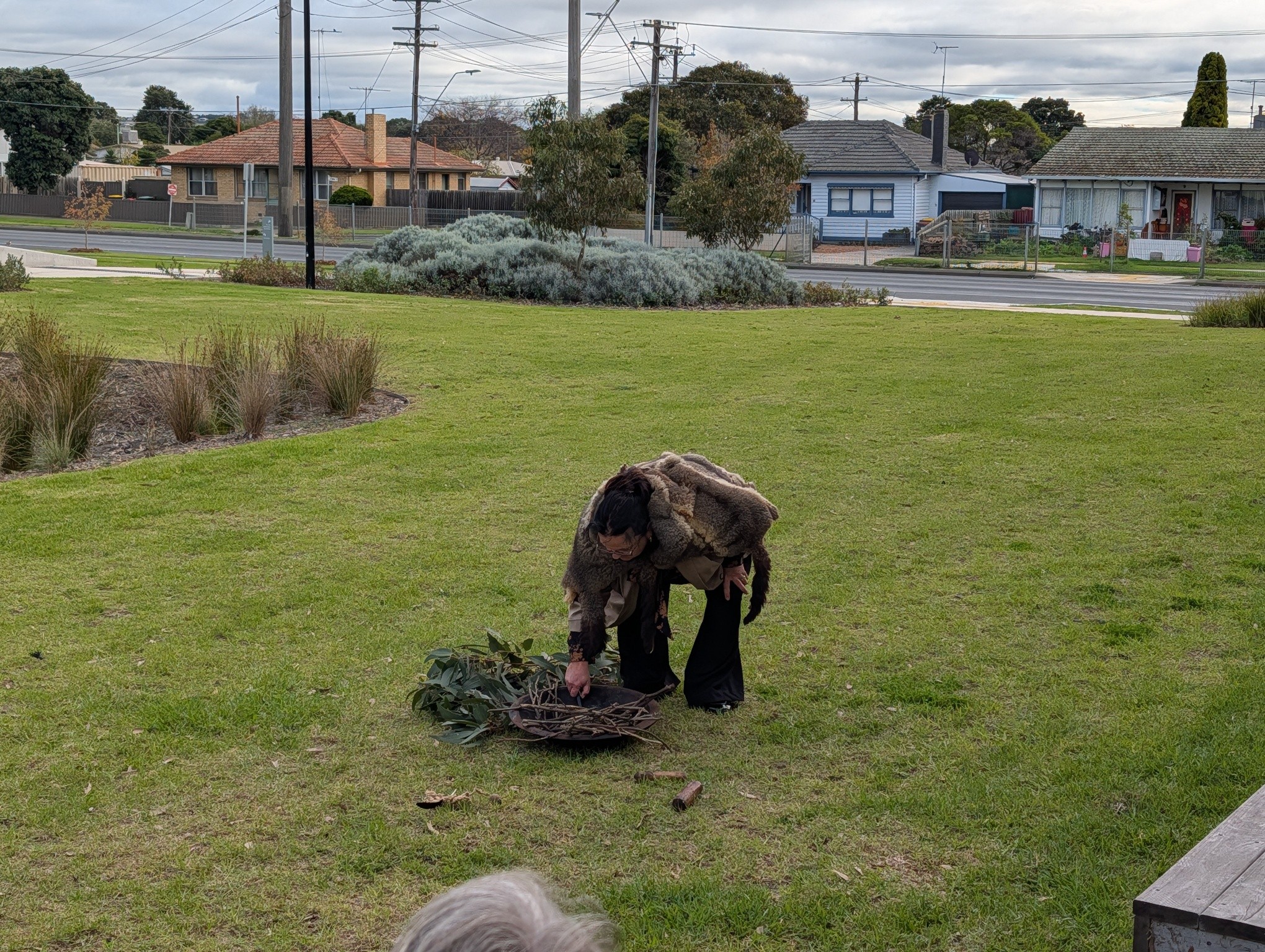 A Wadawurrung Traditional Owner preparing a smoking ceremony on the lawn outside Norlane ARC