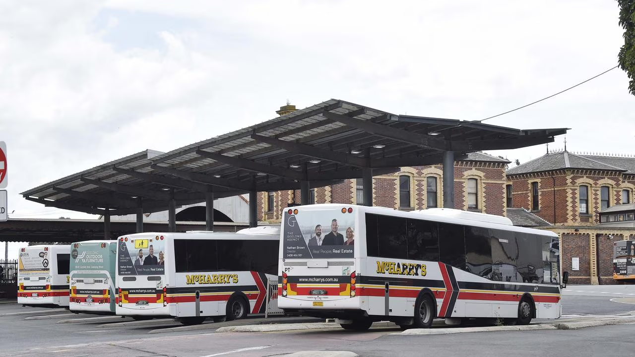 A line of McHarry's buses parked under the shelter at the Geelong bus interchange beside the heritage railway station