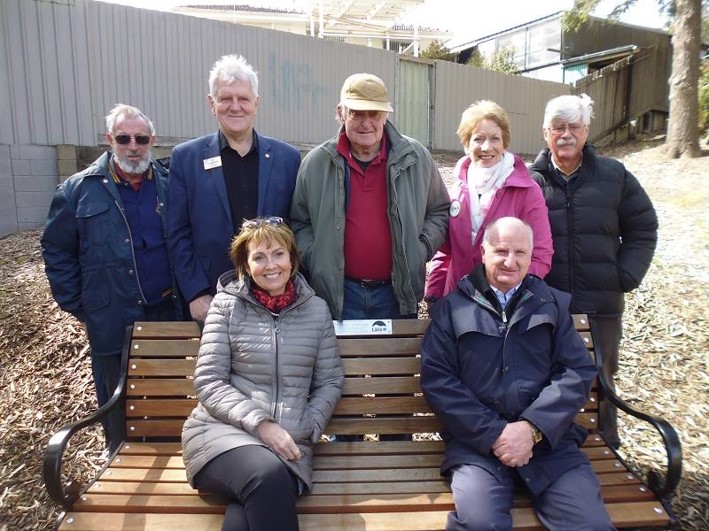 Community members with a newly installed park bench along the Kevin Hoffman Walk