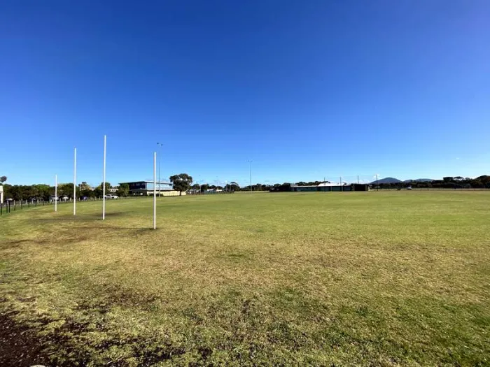 An empty football oval in Lara with goal posts, clubrooms and the You Yangs on the horizon