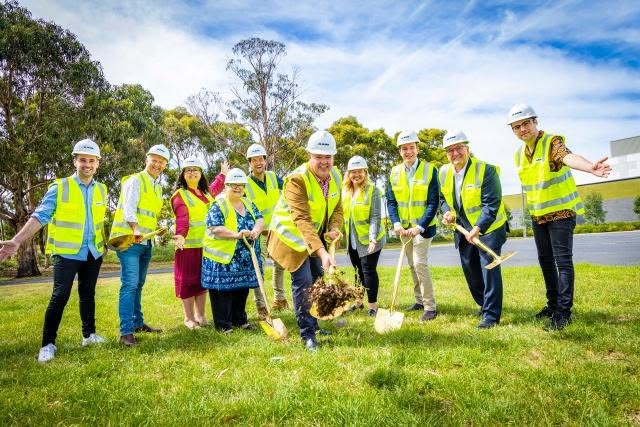 A group in hi-vis vests and hard hats turning the first sod at the Northern Aquatic and Community Hub site