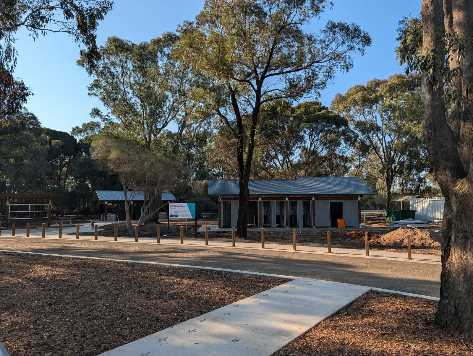 Newly completed visitor building and bollarded path at Serendip Sanctuary, with the project information sign in front