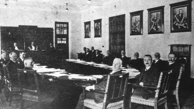 A shire council in session — portraits of past presidents on the wall, minute books on the table. An independent local government, deciding for itself.