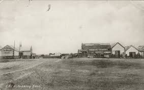 Early black-and-white photograph of Lara looking east — a wide dirt road, a general store and scattered buildings
